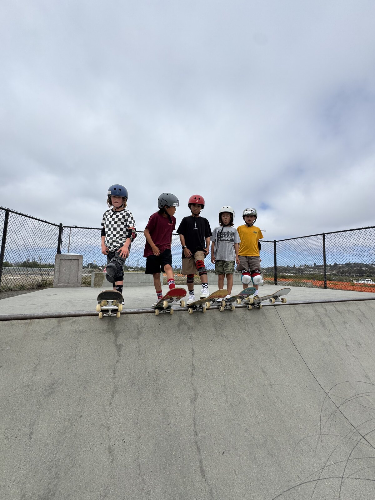 Young skaters lined up on the coping of a ramp before a session